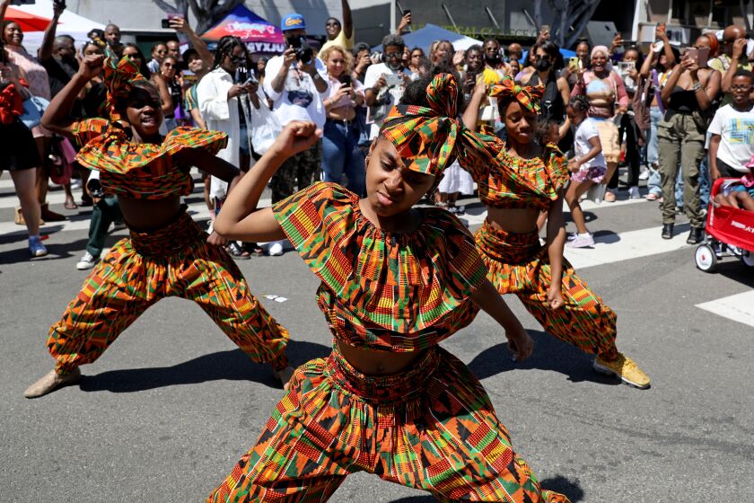 LOS ANGELES, CA - JUNE 18: Zoria (cq) Gardner, 10, left, Kaylen (cq) Brown, 10, and Phynnesc (cq) Jackson, 12, of the Victory Dancers Crenshaw District dance team, dances to music played by the DJ at the Leimert Park Juneteenth Festival in Leimert Park Village on Saturday, June 18, 2022 in Los Angeles, CA. Community-led arts and culture festival - commemorating June 19, 1865 when enslaved Black people in Galveston, Texas, were informed that they were free at last. (Gary Coronado / Los Angeles Times)