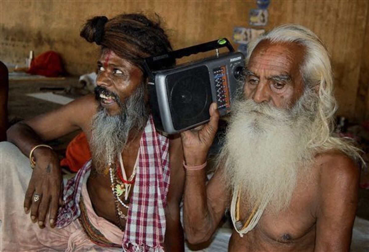 Hindu holy men listen to radio news on the Ayodhya verdict in Mathura, India, Thursday, Sept. 30, 2010. An Indian court ruled Thursday that a disputed holy site that has sparked bloody communal riots across the country in the past should be divided between the Hindu and Muslim communities. However, the court gave the Hindu community control over the section where the now demolished Babri Mosque stood and where a small makeshift tent-shrine to the Hindu god Rama rests. While both Muslim and Hindu lawyers vowed to appeal to the Supreme Court, the compromise ruling seemed unlikely to set off a new round of violence, as the government had feared. (AP Photo)