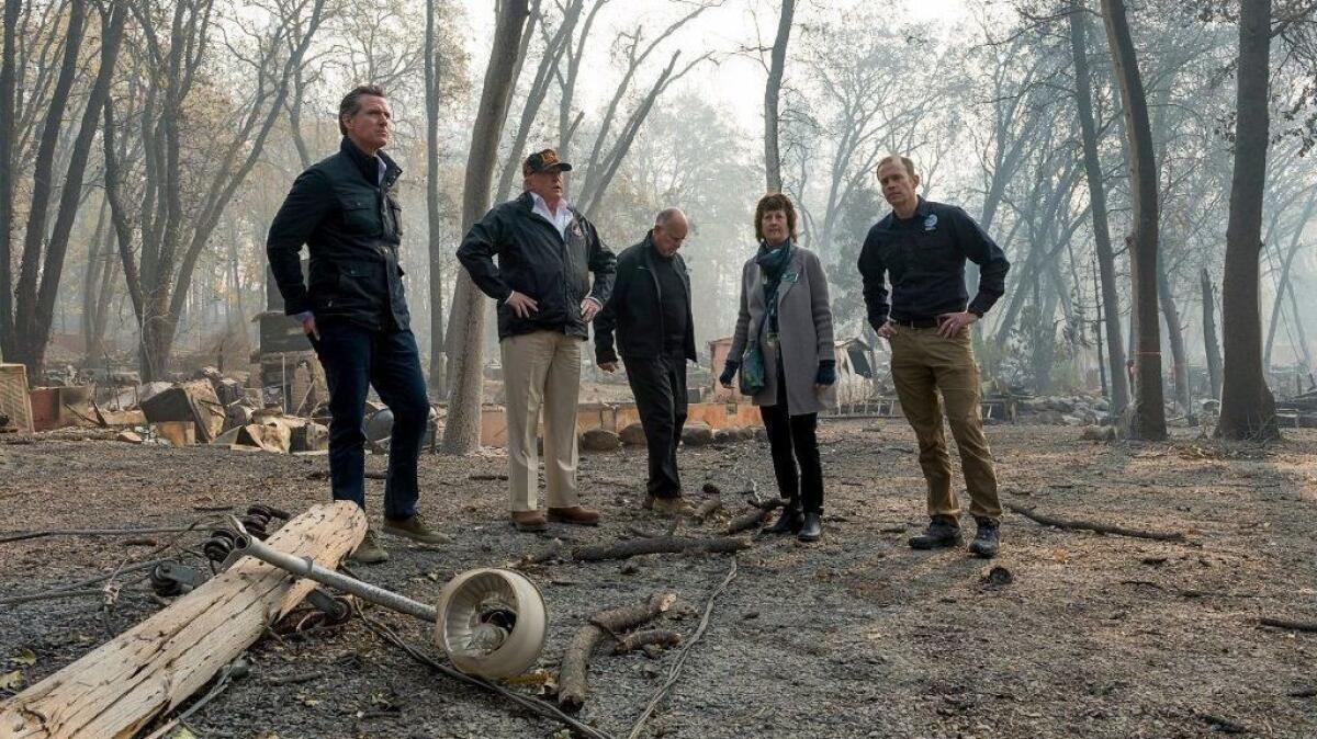 Gov.-elect Gavin Newson, FEMA Director Brock Long, President Trump, Paradise Mayor Jody Jones and Gov. Jerry Brown tour the Skyway Villa Mobile Home and RV Park during Trump's visit to Paradise, Calif., on Nov. 17.