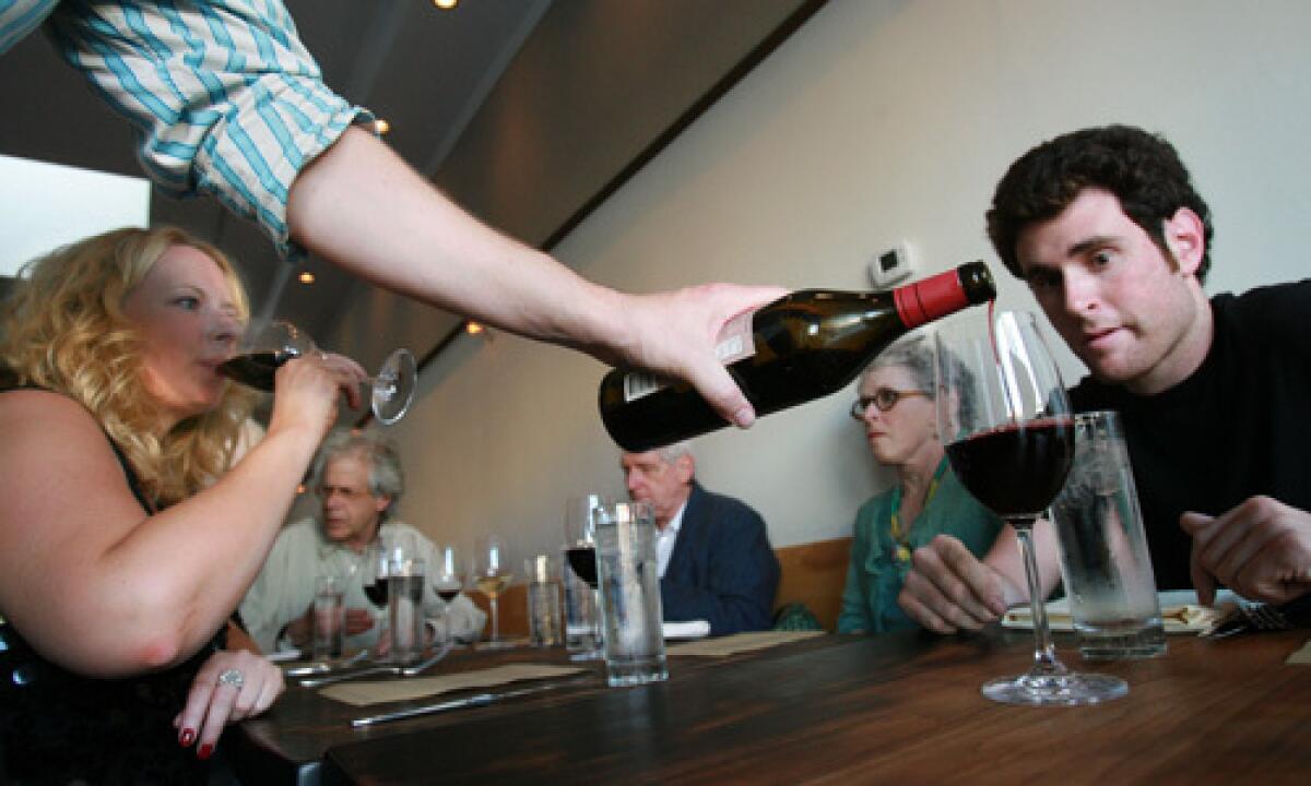 A waiter serves wine to diners at Animal located on Fairfax Ave. in Los Angeles.