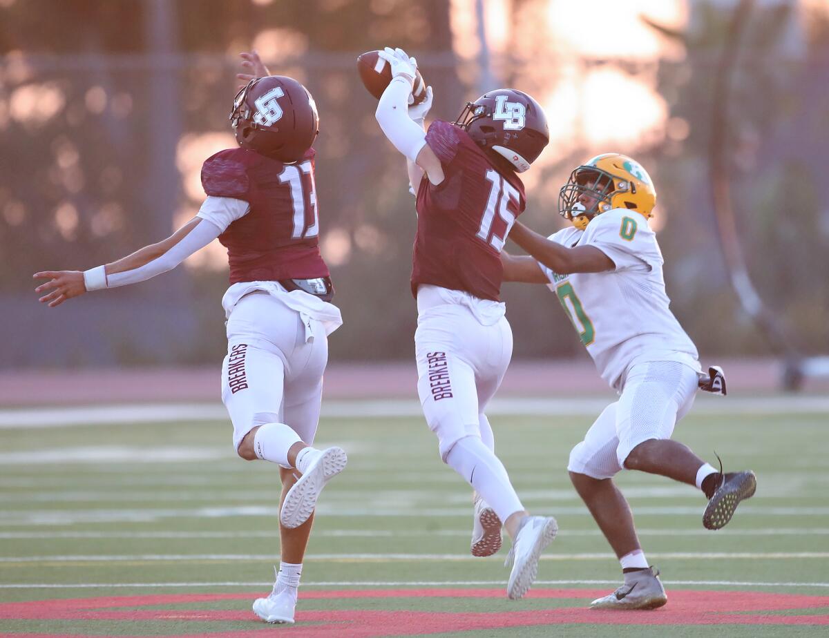 Laguna Beach defender Will Kimball (15) intercepts a pass intended for Kennedy's Deon Bynum (0) during Friday's game.