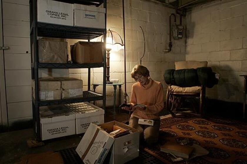 In the basement of her Omaha home, Pam Griffin looks through a box of photos stored with many boxes full of documents that she has accumulated over decades of her husband's imprisonment.