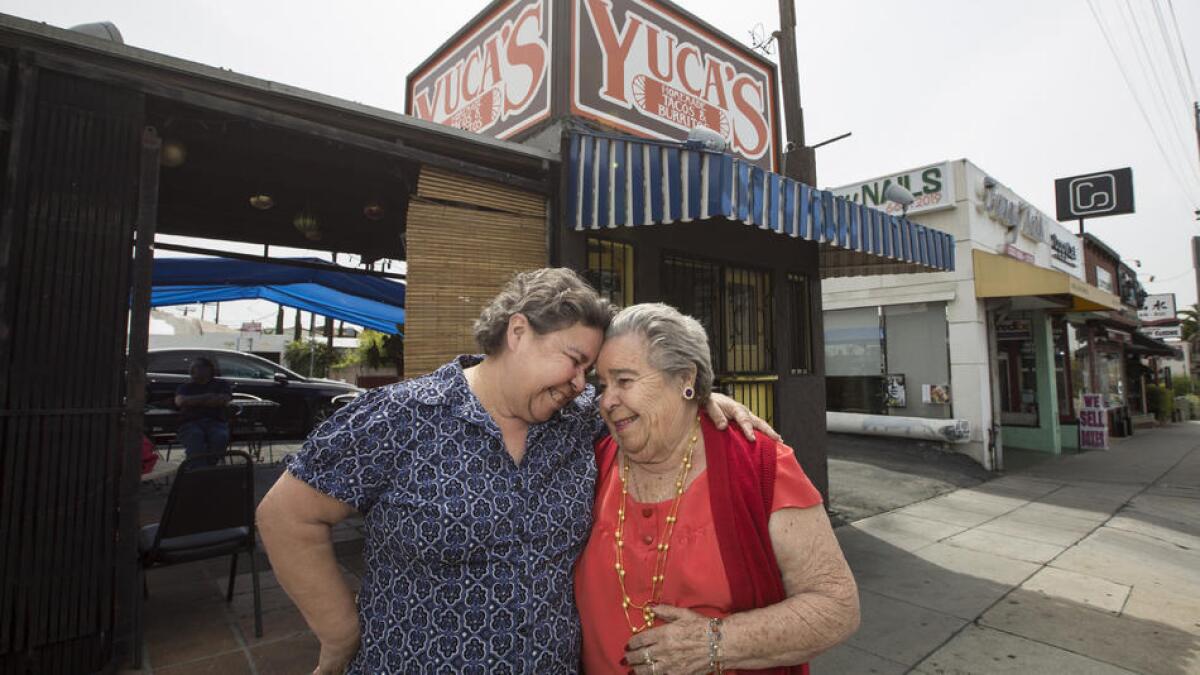Dora Herrera, left, and her mother Soccoro Herrera put their heads together outside their Yuca's tacos location on Hillhurt Avenue in Los Feliz.