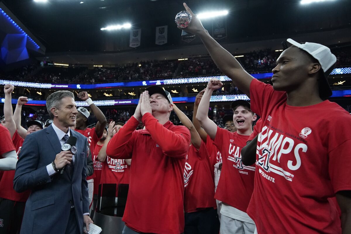 Arizona head coach Tommy Lloyd, center, celebrates after defeating UCLA in an NCAA college basketball game in the championship of the Pac-12 tournament Saturday, March 12, 2022, in Las Vegas. (AP Photo/John Locher)