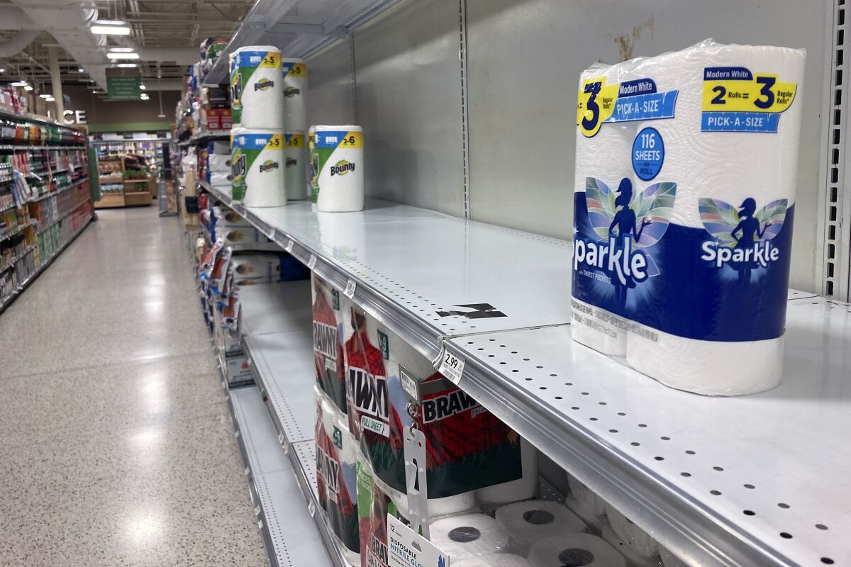 Supermarket shelves with paper goods are nearly empty 