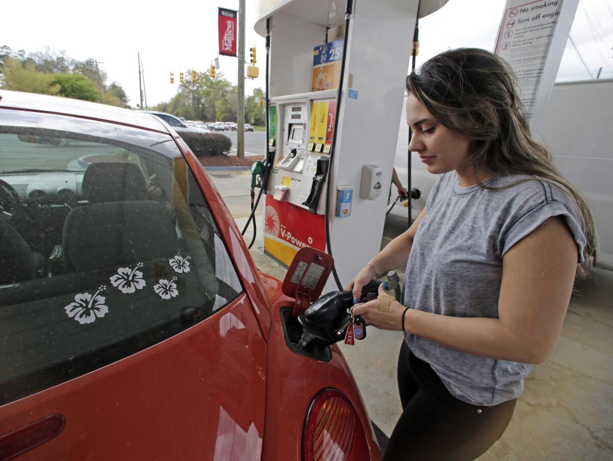 Lucy Perez of Charlotte, N.C., pumps gas at a station in Matthews, N.C., on April 6.
