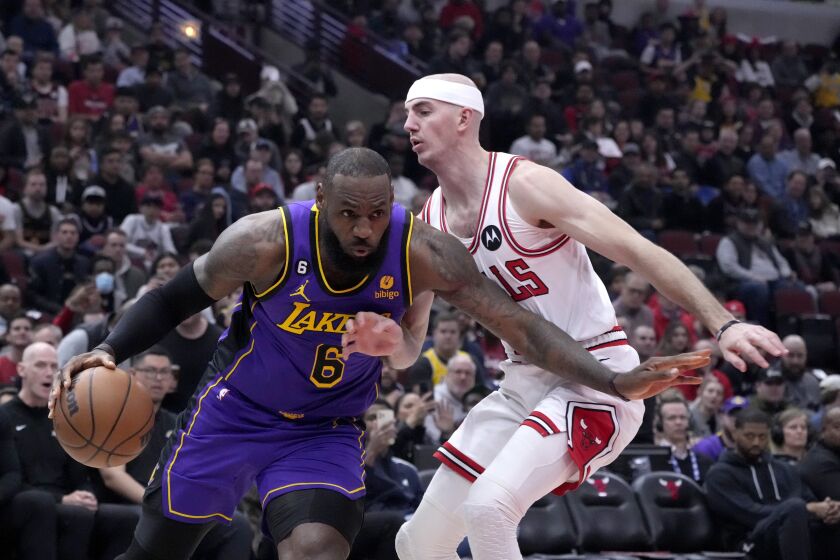 Los Angeles Lakers' LeBron James drives to the basket as Chicago Bulls' Alex Caruso defends during the first half of an NBA basketball game, Wednesday, March 29, 2023, in Chicago. (AP Photo/Charles Rex Arbogast)