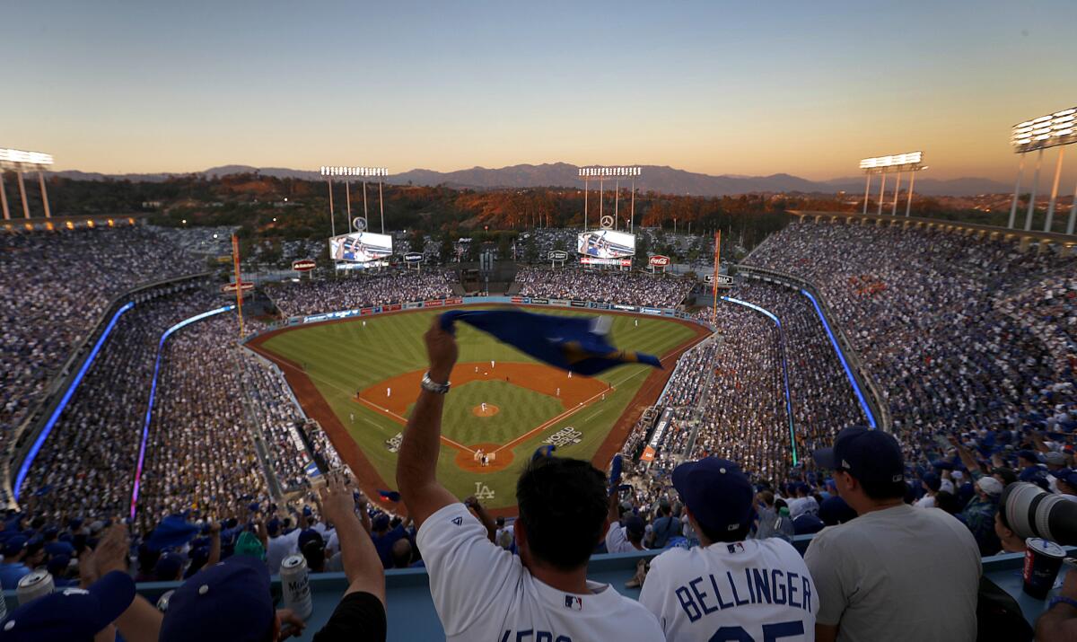 Dodgers fans wave souvenir towels as they cheer on the Dodgers from the top deck section during Game 2 of the World Series at Dodger Stadium.