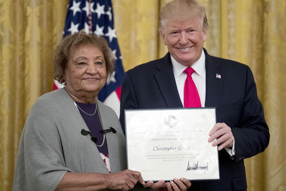 President Trump presents a Certificate of Commendation to Minnie Grant, the mother of Christopher Grant, during a ceremony at the White House on Monday.