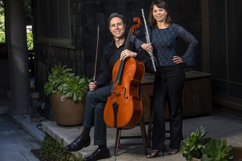 PASADENA, CA - MARCH 05, 2021: Husband and wife Los Angeles Philharmonic players Jonathan and Cathy Karoly are photographed with their instruments, cello and flute, at their home in Pasadena. They shared their stories of struggle, survival, and hope during a year that presented extraordinary challenges and unexpected opportunities for the art form. (Mel Melcon / Los Angeles Times)
