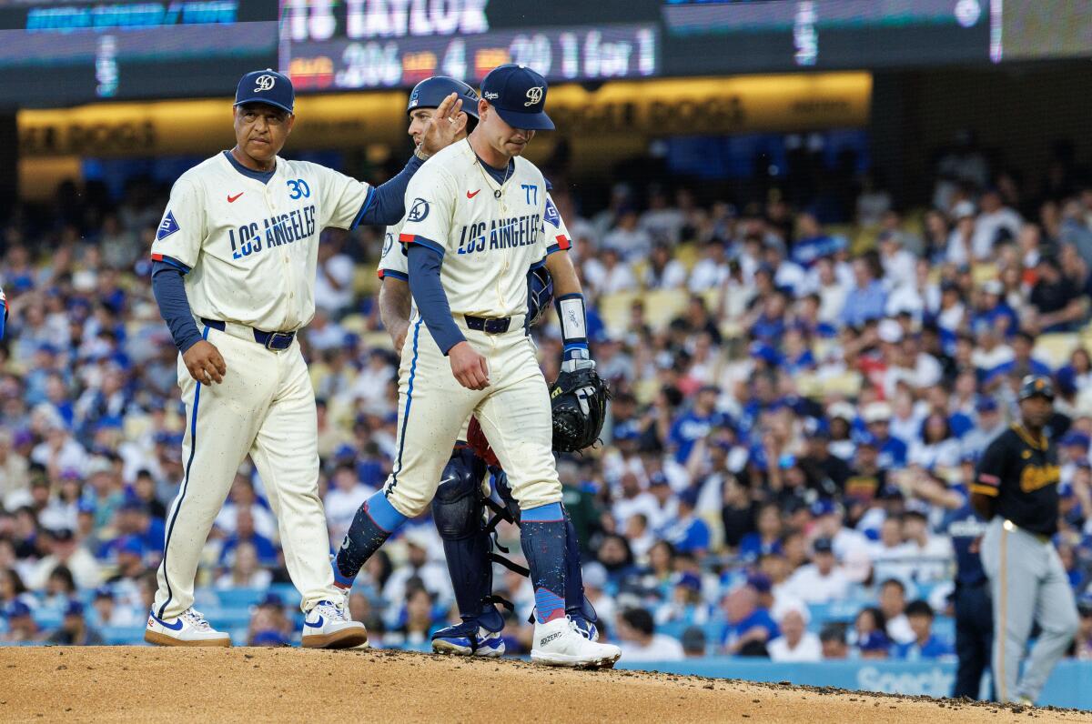 Dodgers manager Dave Roberts consoles starting pitcher River Ryan as he's pulled from the game due to a right arm injury 