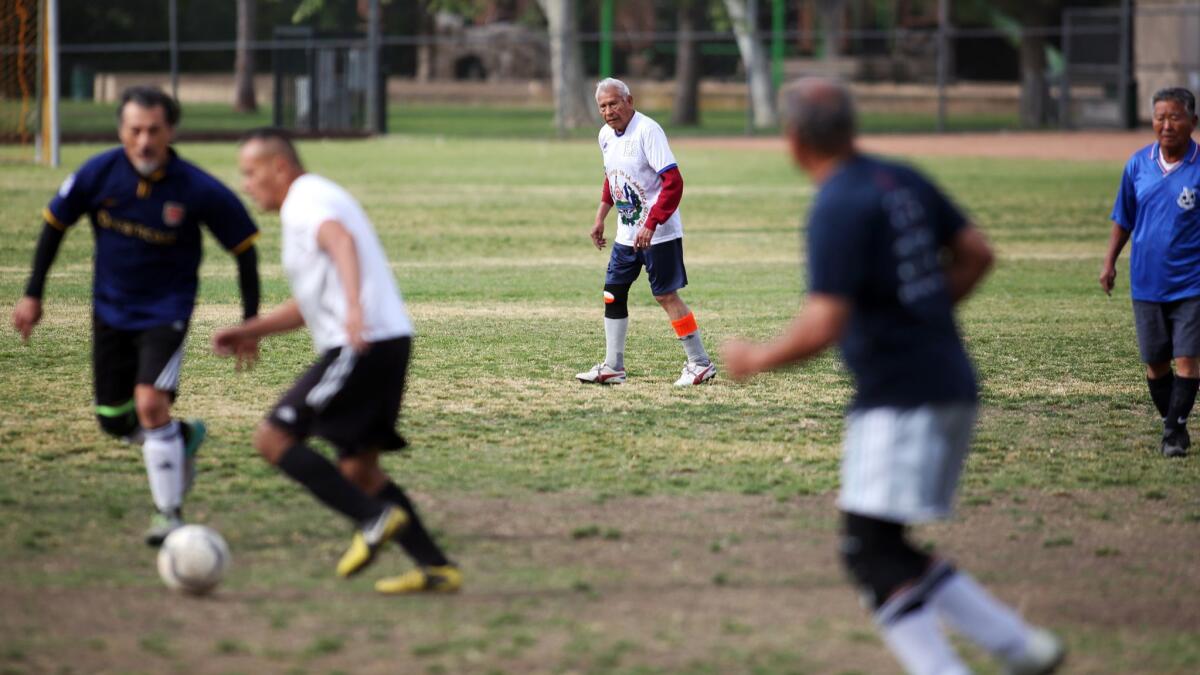 Marcos Gaitan, 90, center, keeps his eye on the ball during a soccer match at North Ranch Playfield.