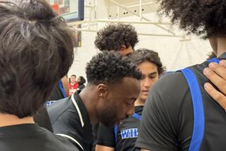 Windward coach DJ Gay talking to his team in the huddle.