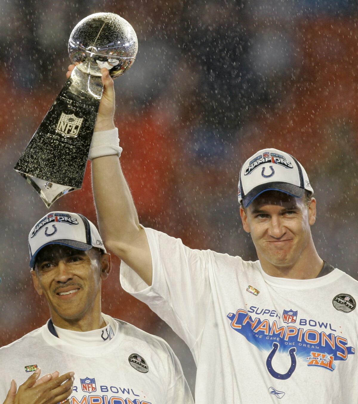 Colts quarterback Peyton Manning lifts the Vince Lombardi Trophy beside coach Tony Dungy following Super Bowl XLI.
