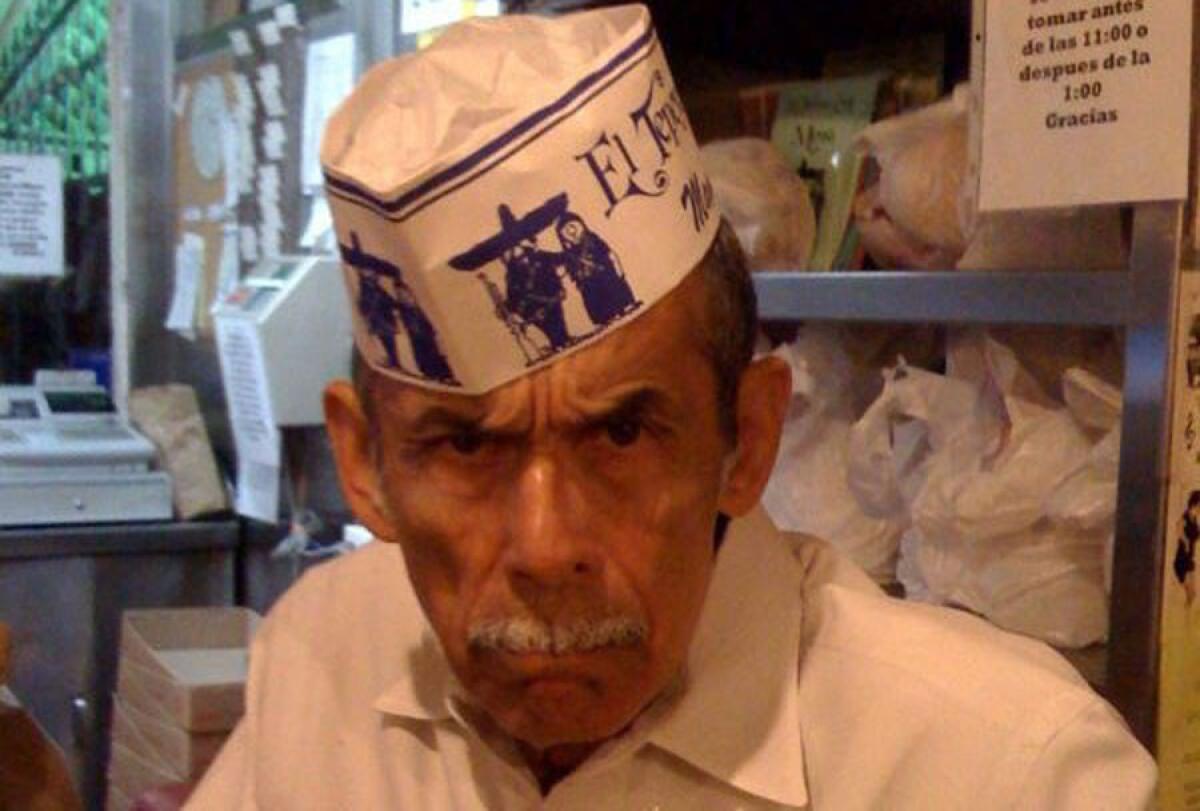 The late Manuel Rojas wears a hat with the "guardians" logo at his family's East L.A. restaurant, El Tepeyac Cafe.