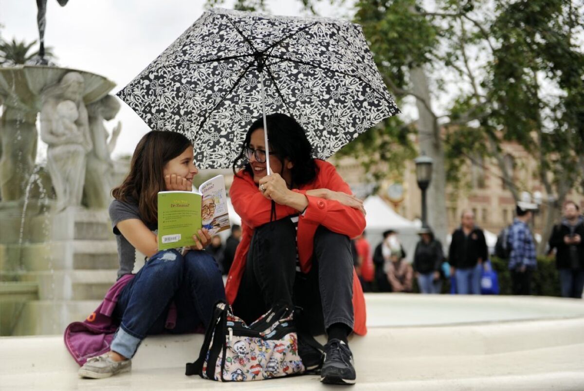 Scarlette Lutz and her mother, Chris, read a book during the 2016 L.A. Times Festival of Books at USC on Saturday.