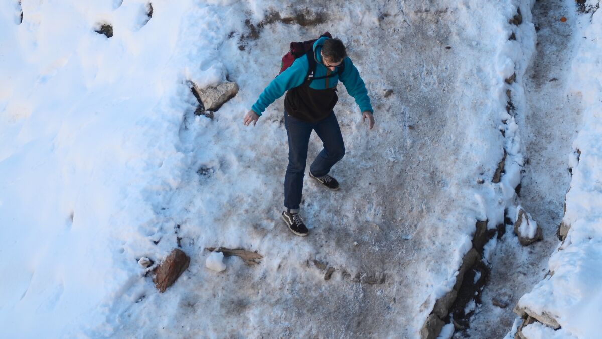 With snow and ice still abundant on a March day at the Grand Canyon's South Kaibab Trail, this sneaker-wearing hiker may be wishing he'd slipped on a pair of crampons for traction.