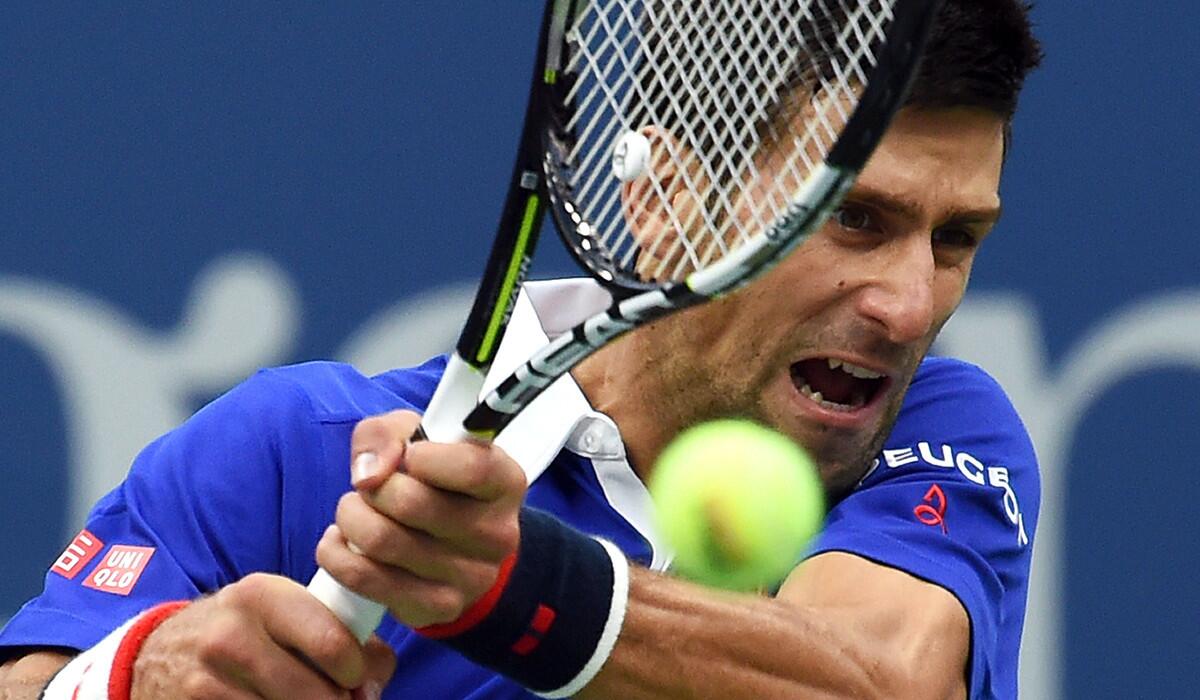 Novak Djokovic returns the ball to Marin Cilic during their U.S. Open Men's singles semifinals match on Friday.