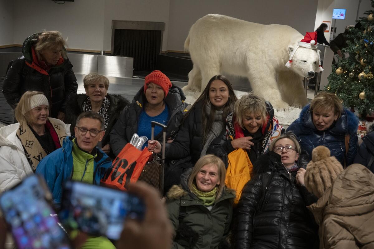 Tourists take pictures with a stuffed polar bear.