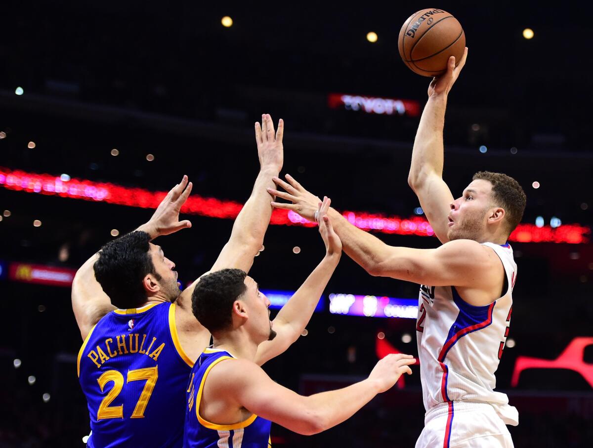 Clippers power forward Blake Griffin (32) shoots over Warriors center Zaza Pachulia (27) and guard Klay Thompson (11) during a 115-98 Warriors win on Dec. 7.