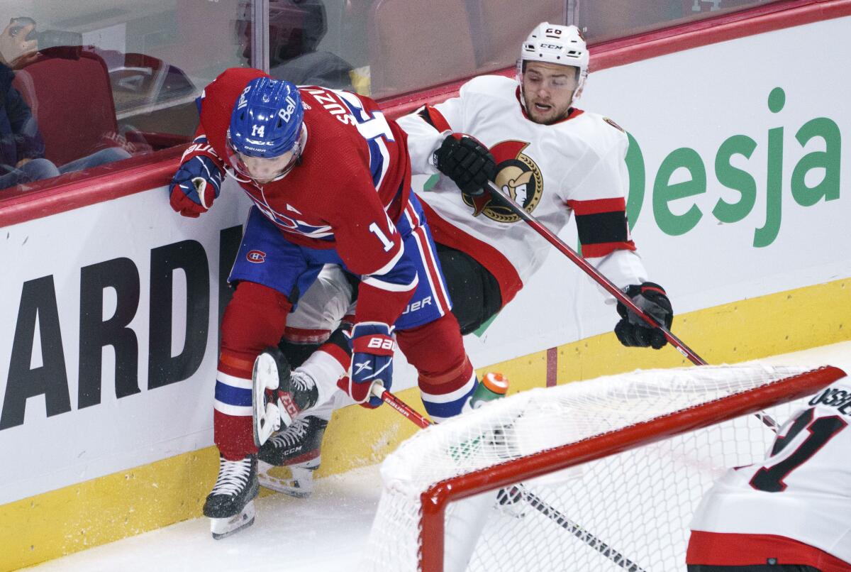 Ottawa Senators' Erik Brannstrom takes a hit from Montreal Canadiens' Nick Suzuki, left, during the first period of an NHL hockey preseason game Thursday, Oct. 7, 2021, in Montreal. (Paul Chiasson/The Canadian Press via AP)