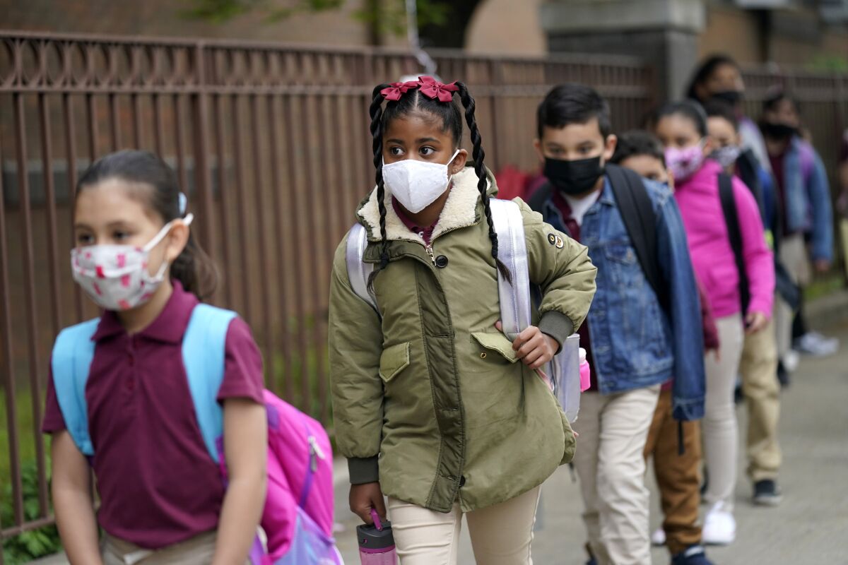 FILE - Students line up to enter Christa McAuliffe School in Jersey City, N.J., Thursday, April 29, 2021. Gov. Phil Murphy is set to announce Friday, Aug. 6 that New Jersey students from kindergarten to 12th grade and staff members will be required to wear masks in schools when the new year begins in a few weeks, as COVID-19 cases rise in the state. (AP Photo/Seth Wenig, File)