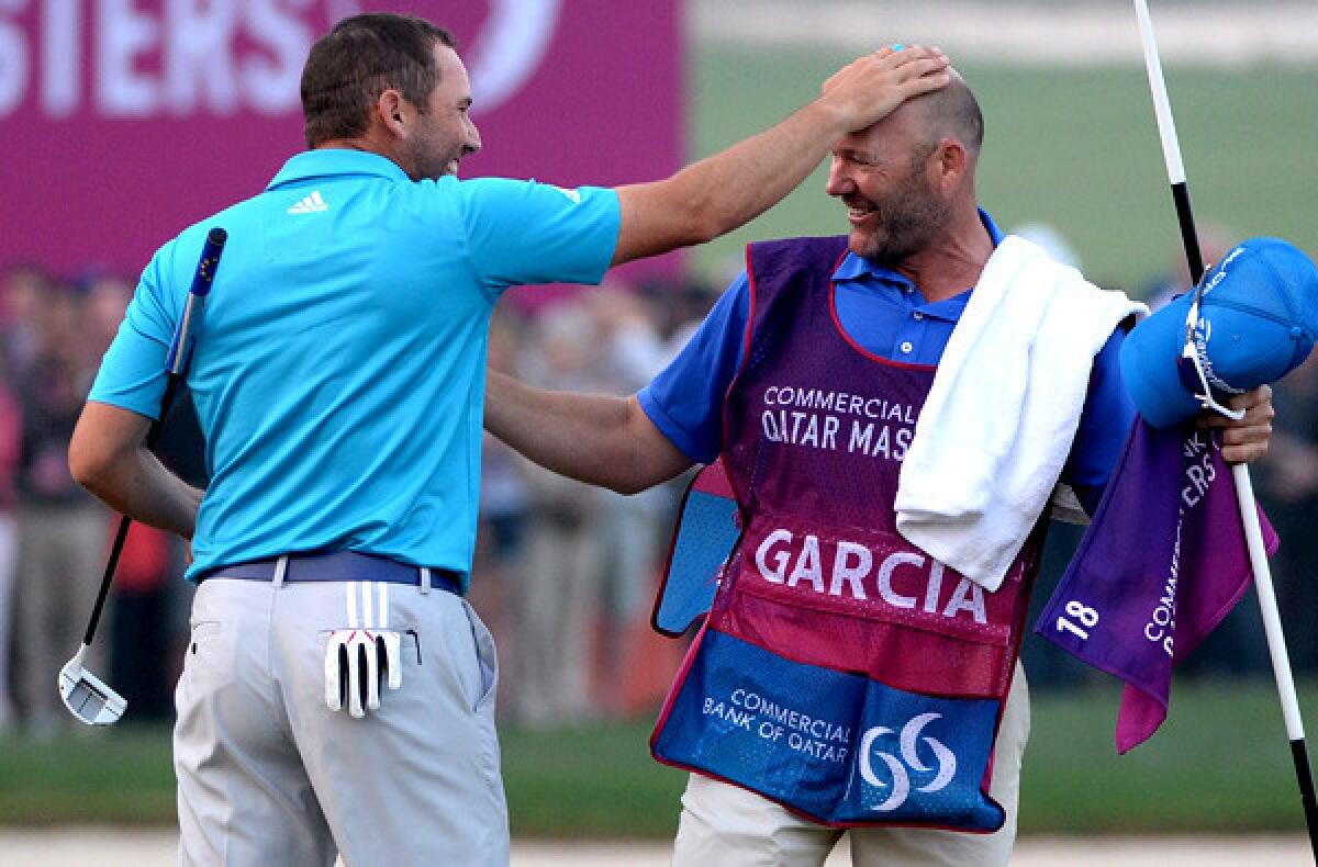 Sergio Garcia celebrates with his caddie after winning the Qatar Masters on the third playoff hole Saturday in Doha.