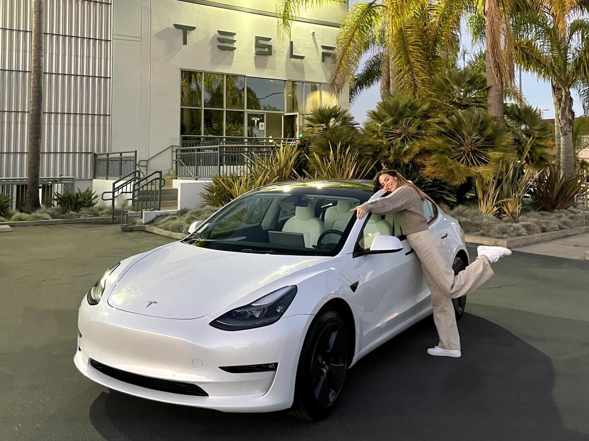 Ariana Escalante leans against a Tesla Model 3 long range