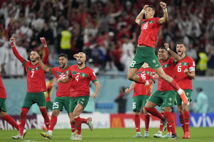 Morocco's Jawad El Yamiq, top, celebrates with teammates after defeating Spain via penalty shootout at the World Cup