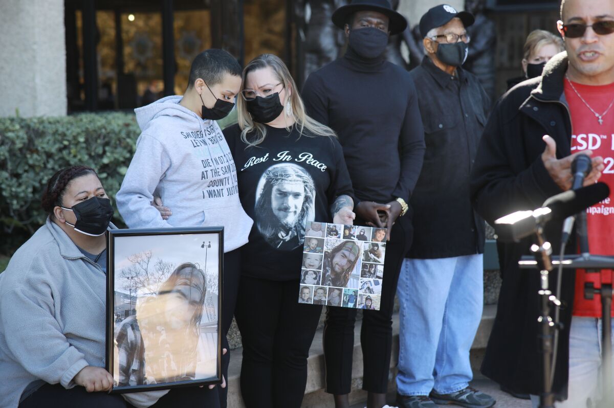 Family members of inmates hold photos and talk about high death rates in jail at San Diego Sheriff's headquarters Friday
