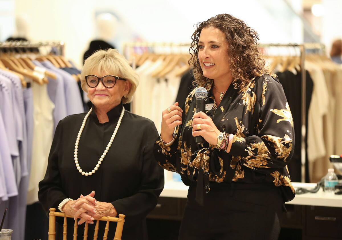 Working Wardrobes CEO Bonnie Pomush, right, welcomes guests to the OC Women2Women Club benefit luncheon.