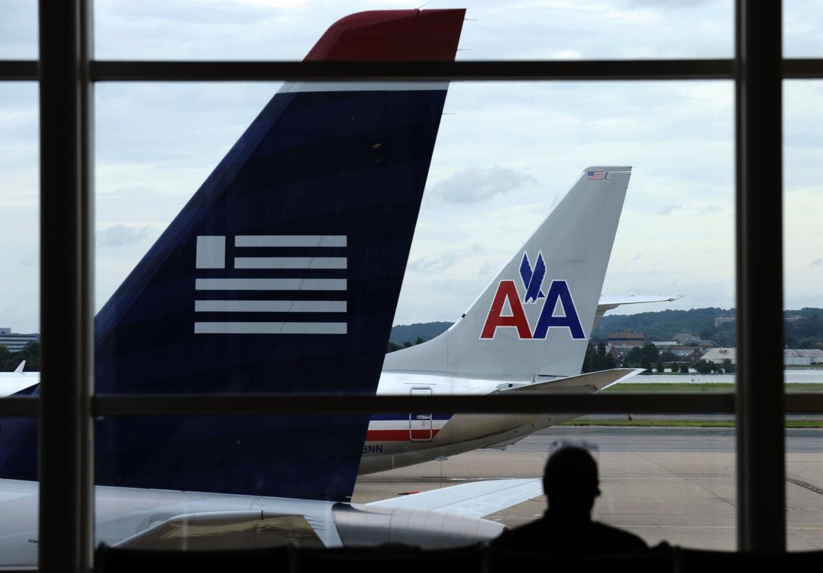 An American Airlines plane and a US Airways plane are parked at Washington's Ronald Reagan National Airport in Washington.
