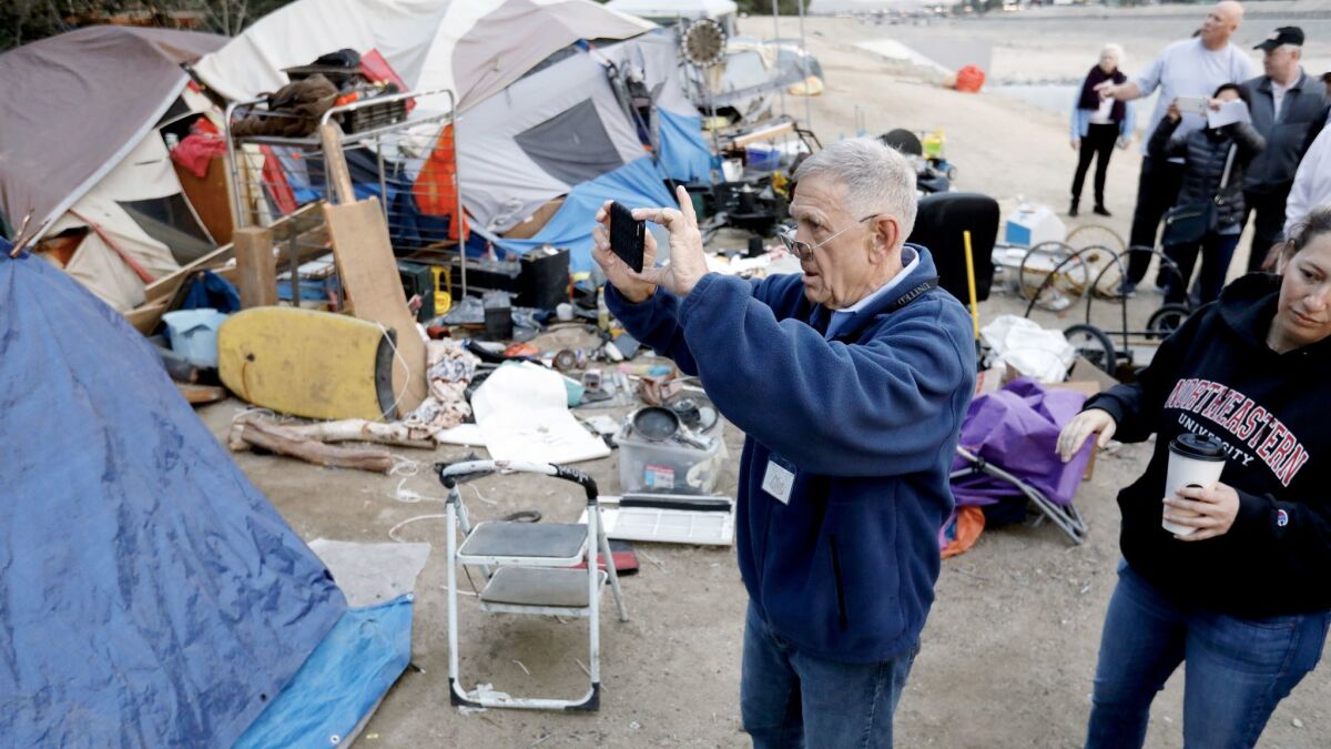 U.S. District Judge David O. Carter surveys the homeless encampment along the Santa Ana River in Anaheim.