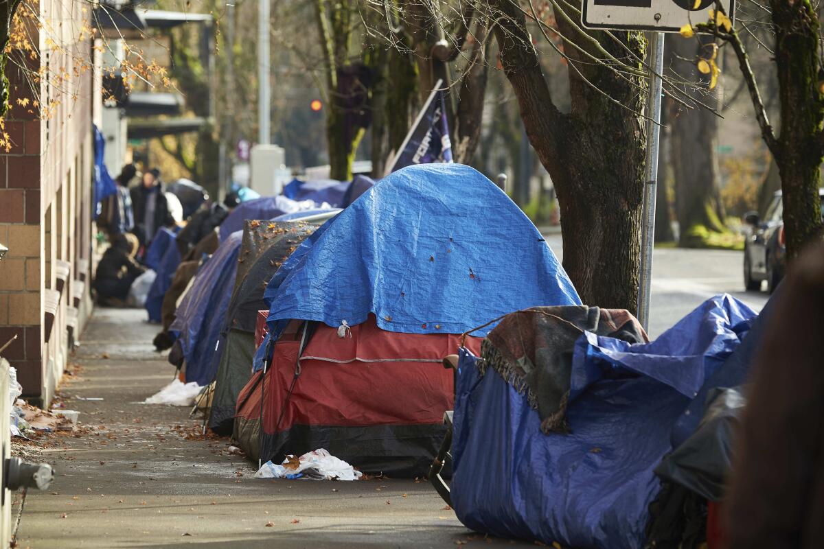Tents line the sidewalk in downtown Portland, Ore.