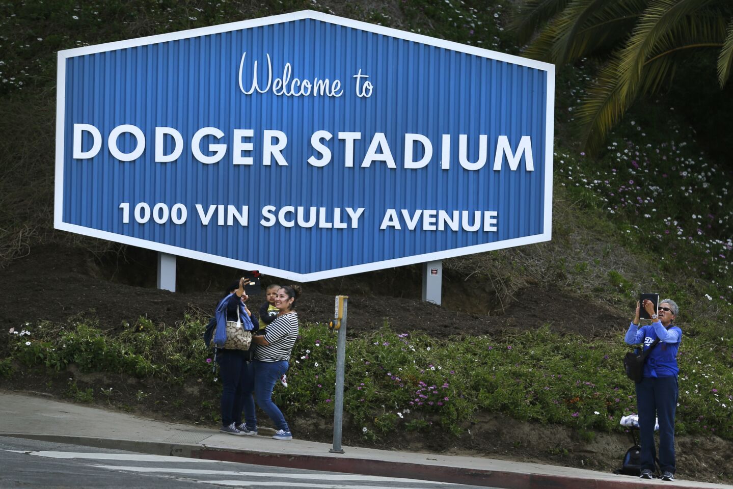 People gather to take photographs along the newly named Vin Scully Avenue.