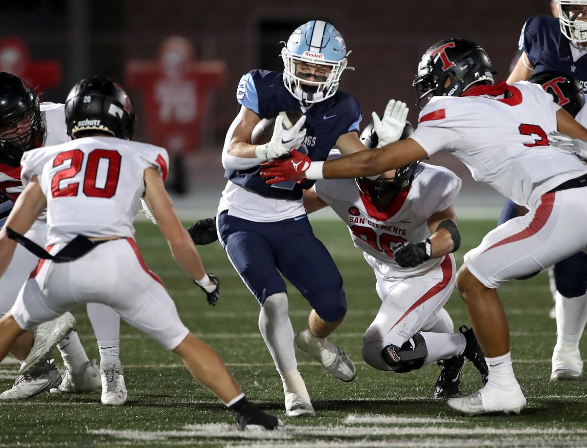 Corona del Mar's Wyatt Lucas is met by a group of San Clemente defenders as he runs through a gap on Friday night.