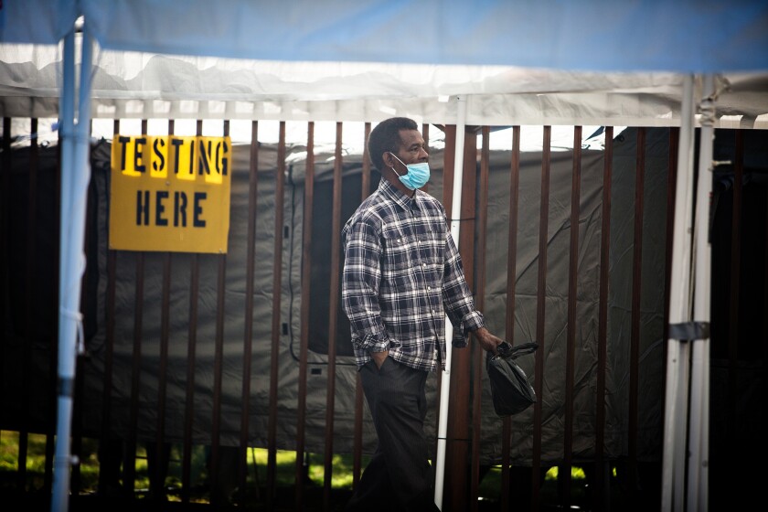 A man waits Tuesday outside Kedren Community Health Center, which is offering walk-up coronavirus testing.