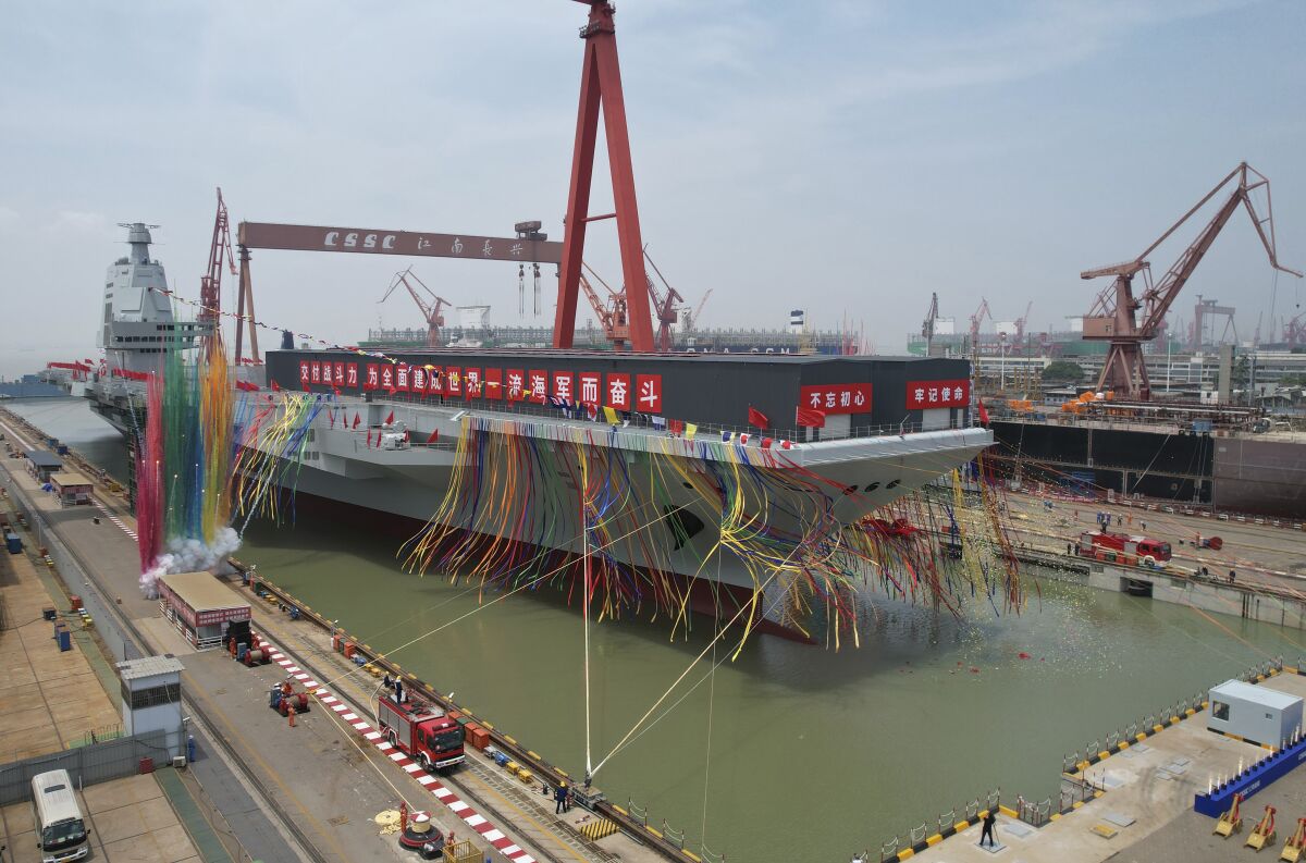 In this photo released by Xinhua News Agency, coloured smoke mark the launch ceremony for China's third aircraft carrier christened Fujian at a dry dock in Shanghai on Friday, June 17, 2022. China on Friday launched its third aircraft carrier, the first such ship to be both designed and built entirely within the country. (Li Gang/Xinhua via AP)