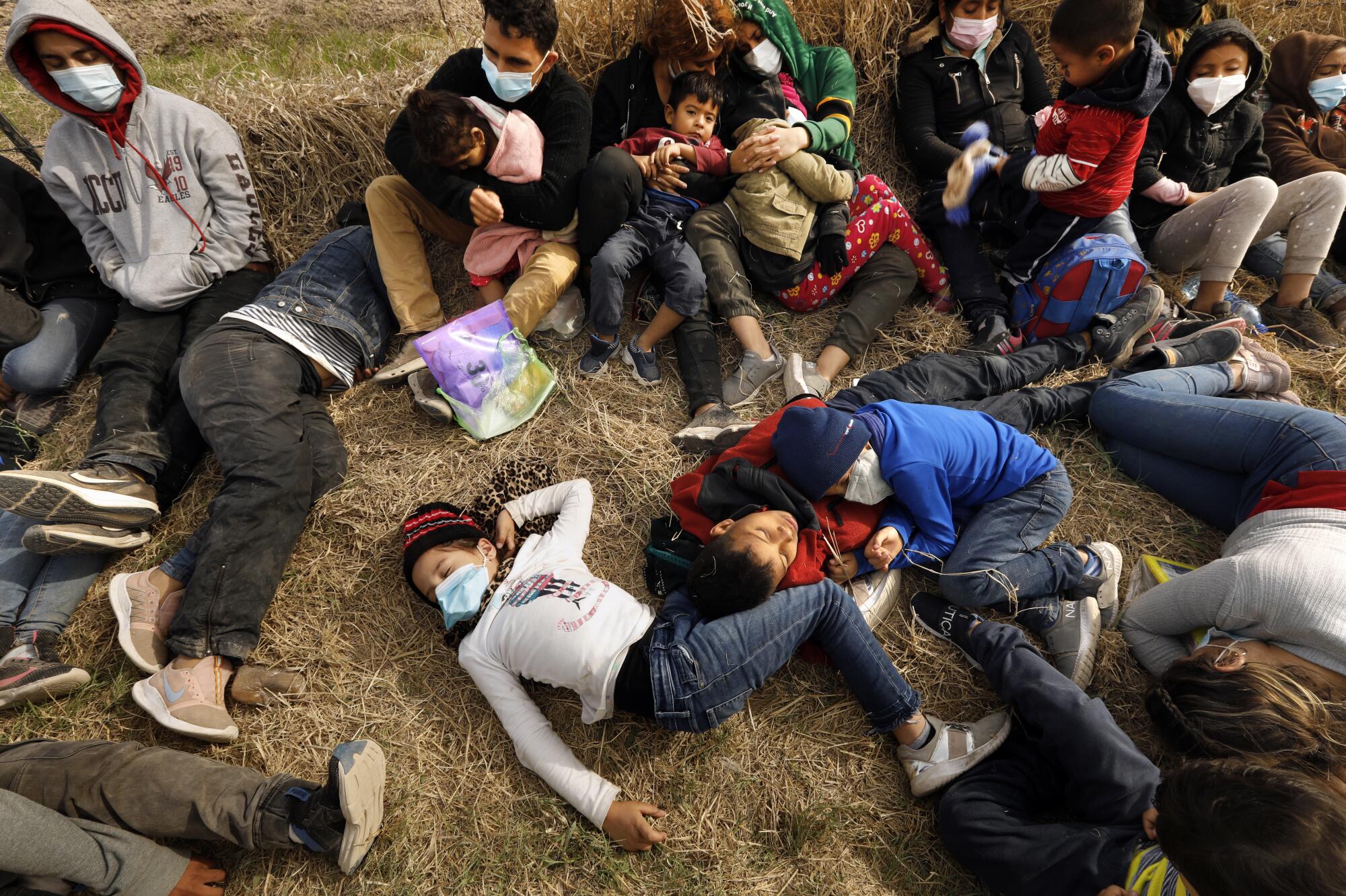 Detained asylum seekers, including children,  sleep on the ground.