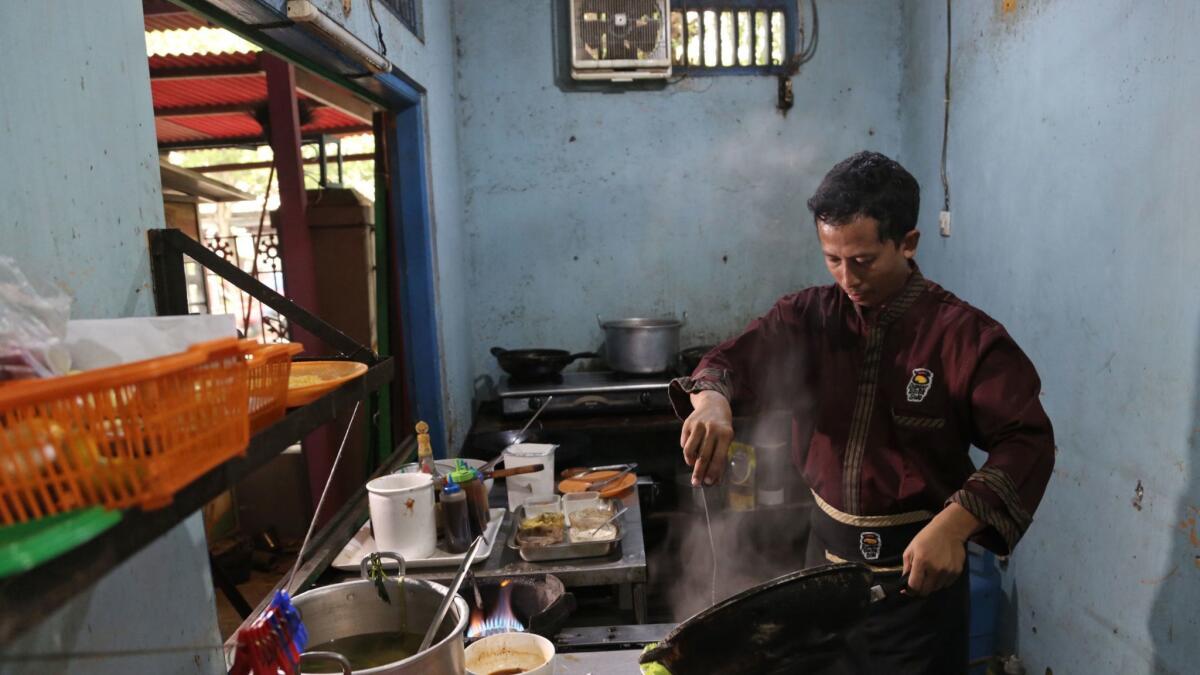 Machmudi Hariono, a former militant, cooks in the kitchen of his restaurant in Solo, Central Java, Indonesia.