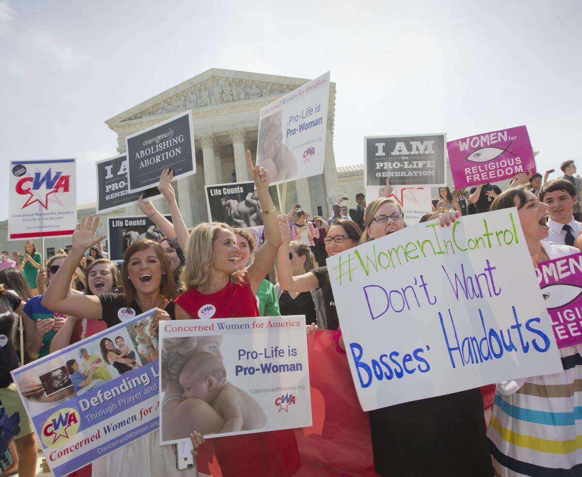 Demonstrators react Monday to hearing the Supreme Court's decision on the Hobby Lobby case outside the court.