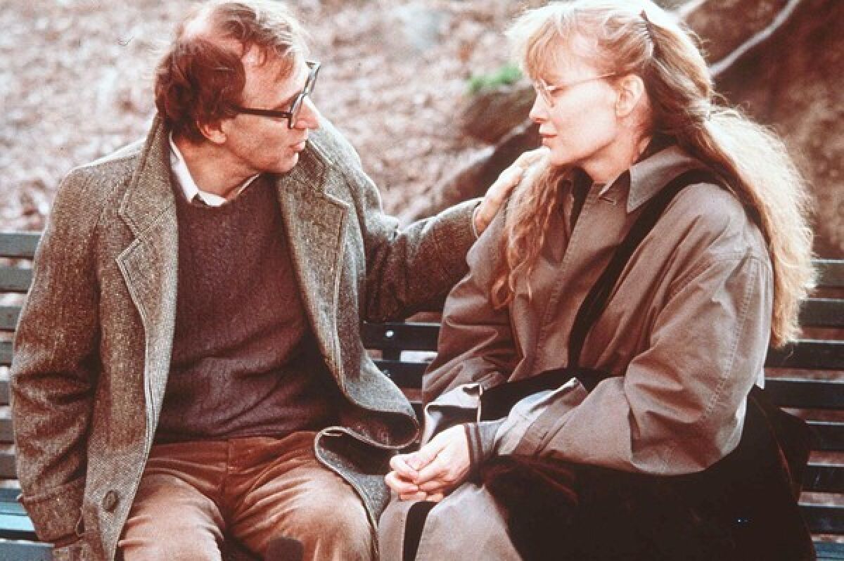 Woody Allen sits on a bench with Mia Farrow in "Crimes and Misdemeanors"
