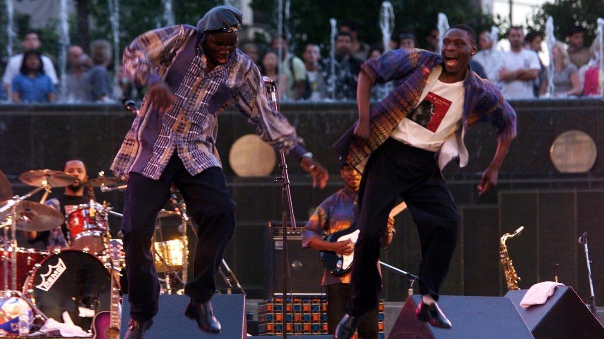 Oliver Mtukudzi, left, and a member of his band dance on stage during a 1999 performance at the California Plaza in Los Angeles.