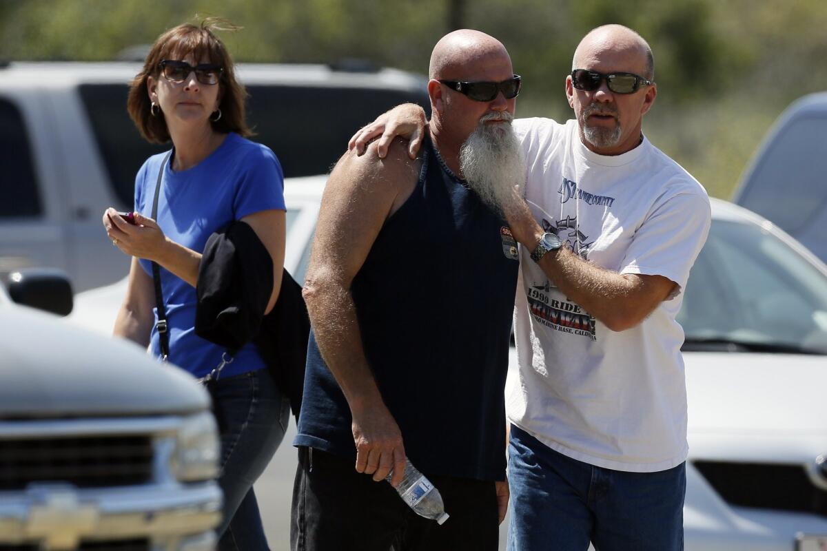 Russ Jack, center, is comforted Tuesday as family members and friends wait for word on Jack’s daughter, Kyndall, and companion Nicholas Cendoya, who reported themselves lost in Holy Jim Canyon in the Cleveland National Forest on Sunday before their cellphone went dead.