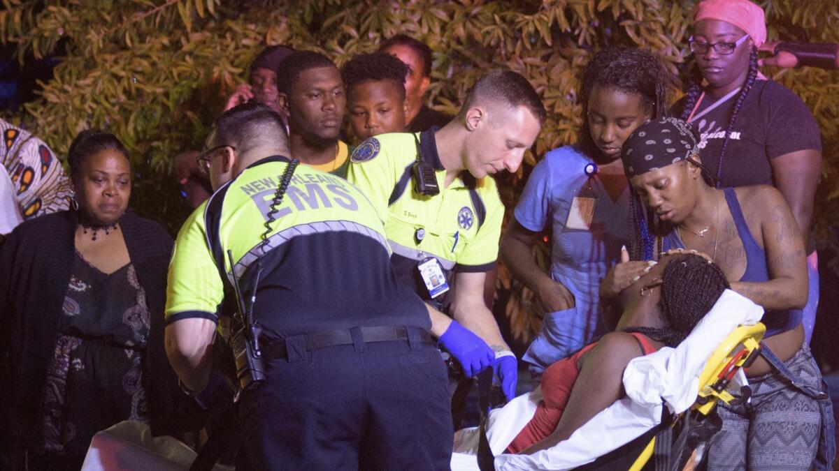 Emergency workers tend to a person that fainted near the scene of a shooting in New Orleans, Saturday night, July 28, 2018.