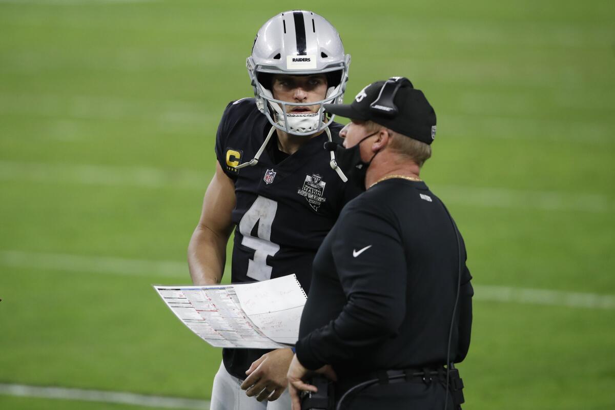 Las Vegas Raiders quarterback Derek Carr speaks with coach Jon Gruden during a game against the Miami Dolphins on Dec. 26.