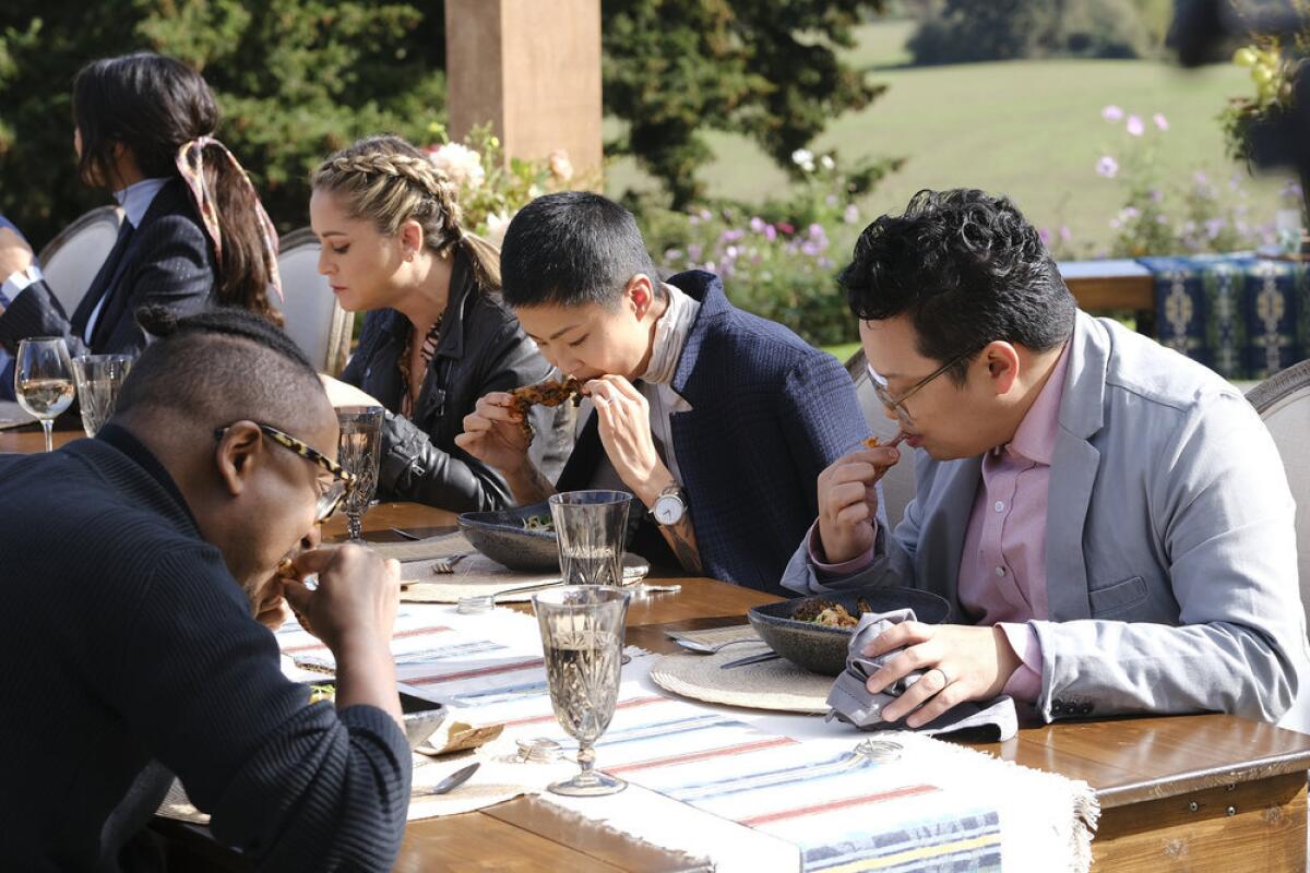 A group of people eating ribs at an outdoor table