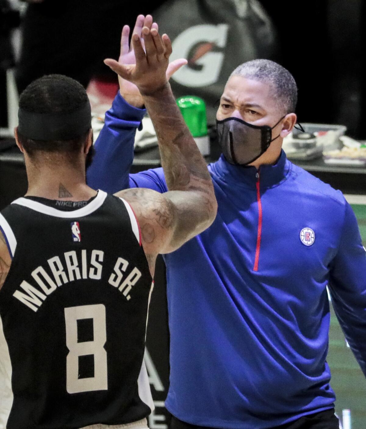 Clippers coach Tyronn Lue high-fives forward Marcus Morris as he comes off the court