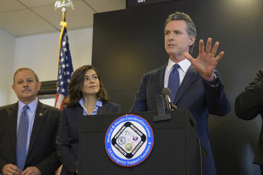 California Governor Gavin Newsom speaks to members of the press at a news conference in Sacramento, Calif., Thursday, Feb. 27, 2020. Newsom spoke about the state's response to novel coronavirus, also known as COVID-19. Behind him are Director of the Governor's Office of Emergency Services Mark Ghilarducci, right, and California Department of Public Health Director and State Health Officer Dr. Sonia Angell. Yesterday, the Centers for Disease Control and Prevention confirmed a possible first case of person-to-person transmission of COVID-19 in California in the general public.(AP Photo/Randall Benton)