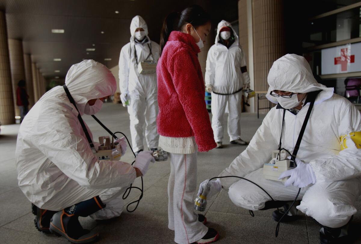 In March 2011, a young evacuee is screened for leaked radiation from the damaged Fukushima nuclear plant in Japan.